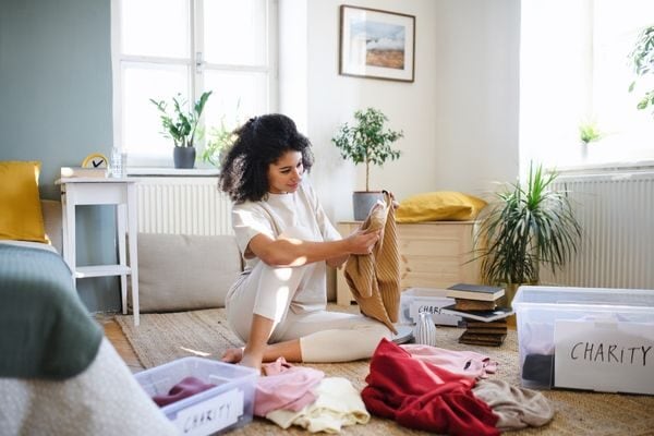 woman sorting clothes; how to declutter fast your house in one day