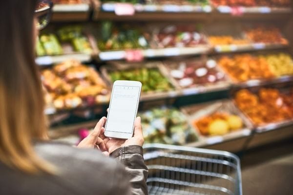 woman with phone in grocery store