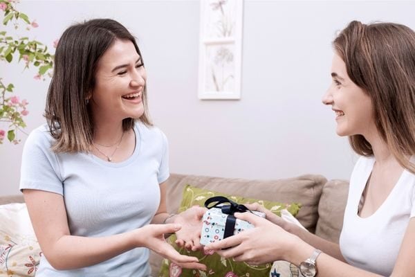 two women exchanging a gift; small affordable thank you gift ideas