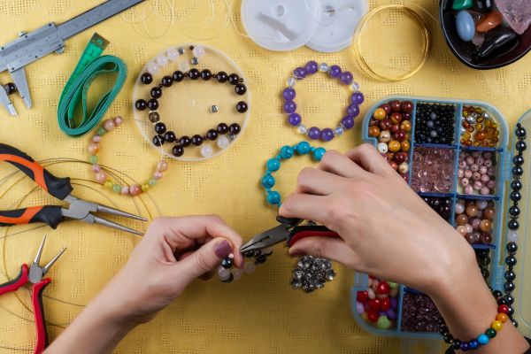 kid making beaded jewelry