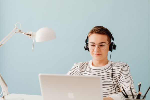 teenage boy with headphones on computer; businesses for kids to start