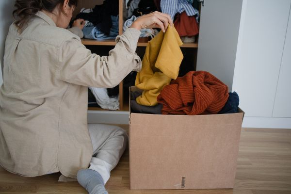 woman putting clothes in a box