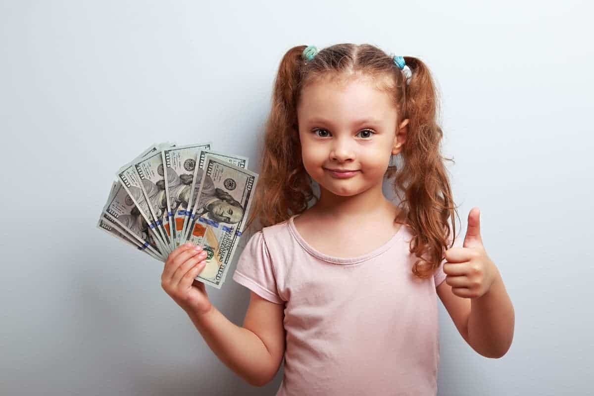 child holding dollar bills; consumable gifts for minimalist