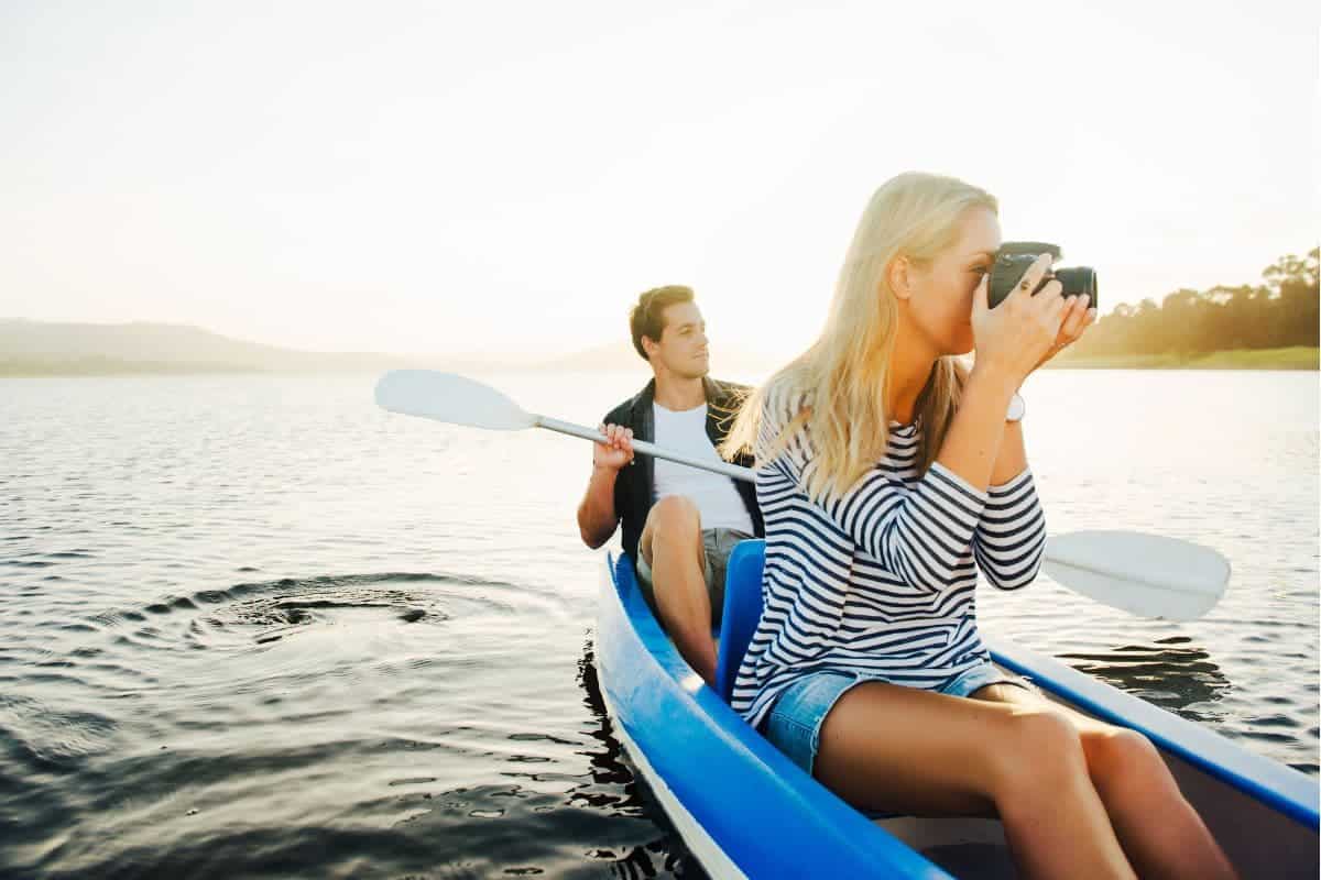 woman and man on a kayak and taking pictures