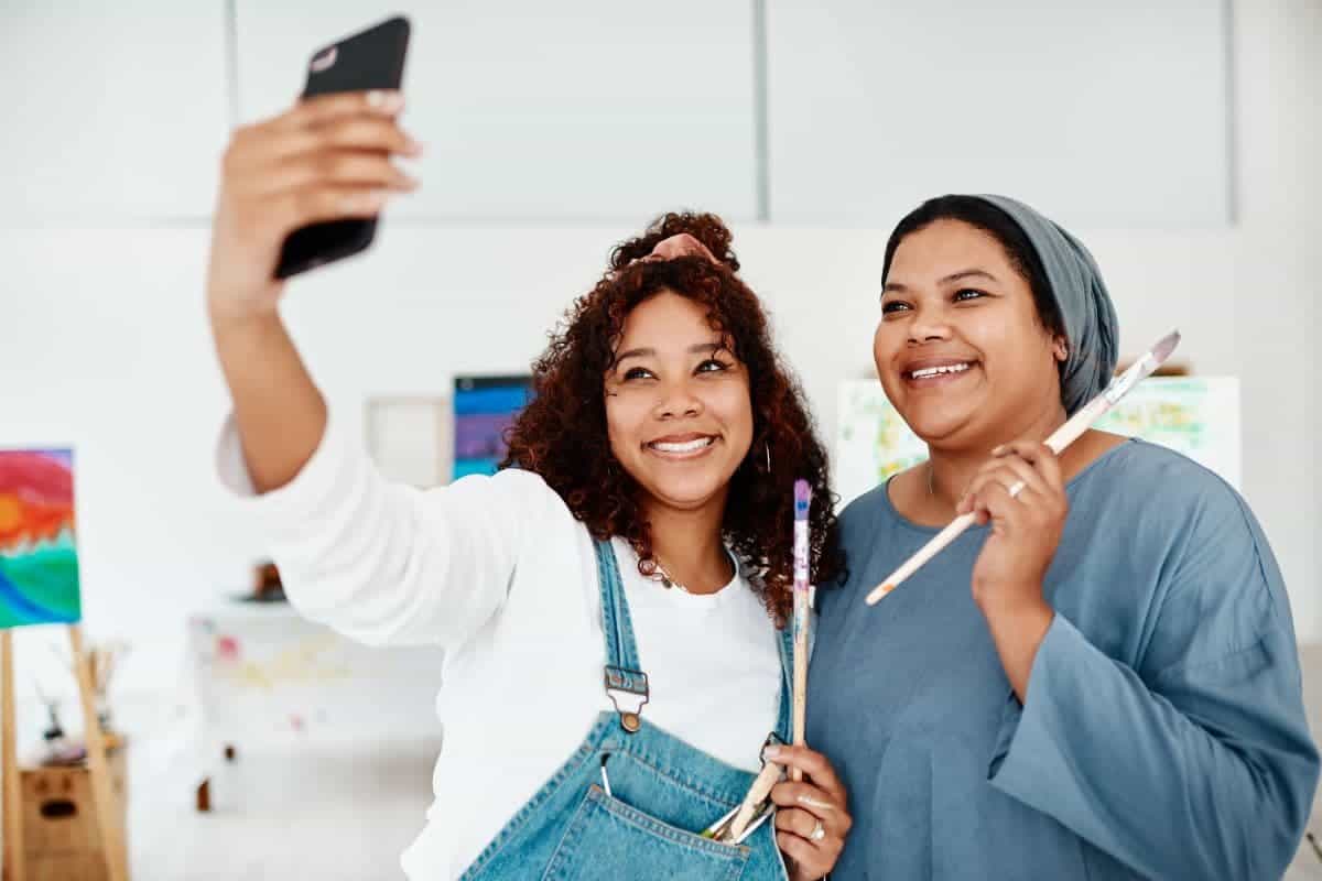 two women taking a selfie and painting