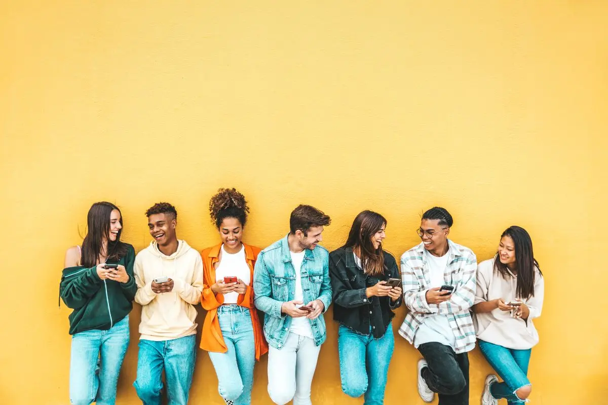 Teens on their phones smiling
