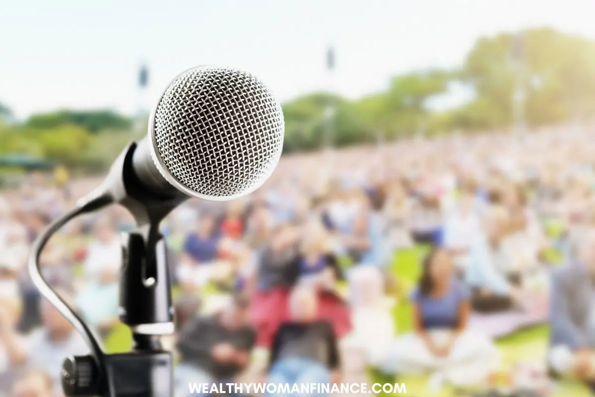 outdoor concert, microphone and group sitting on grass