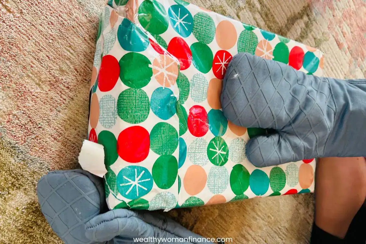 funny Christmas party money game, oven mitts, dice, present